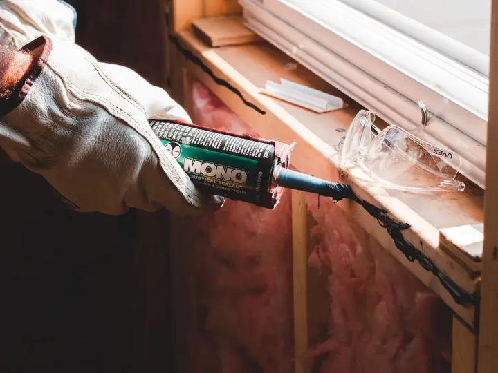 Sealant being applied along a window frame
