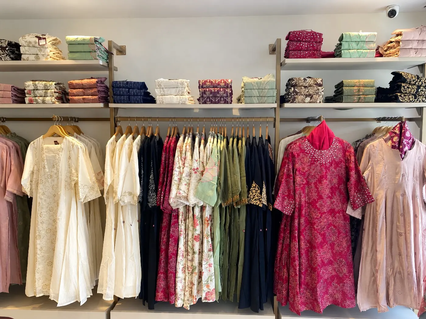 Feature wall with folded stock on shelves above and garment rails below