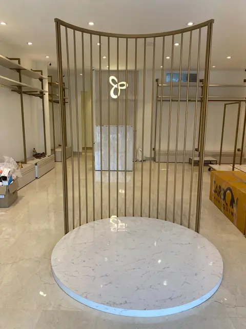 Vismay Chennai: curved brass-finish screen and marble plinth