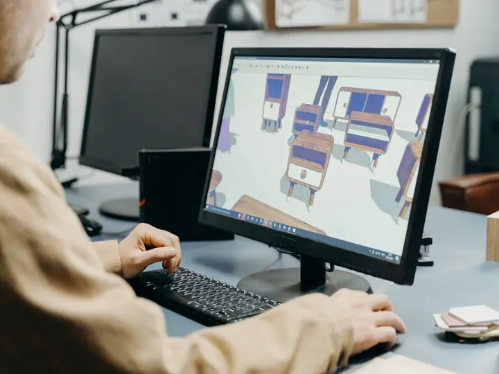 Designer building a 3D furniture layout on a computer